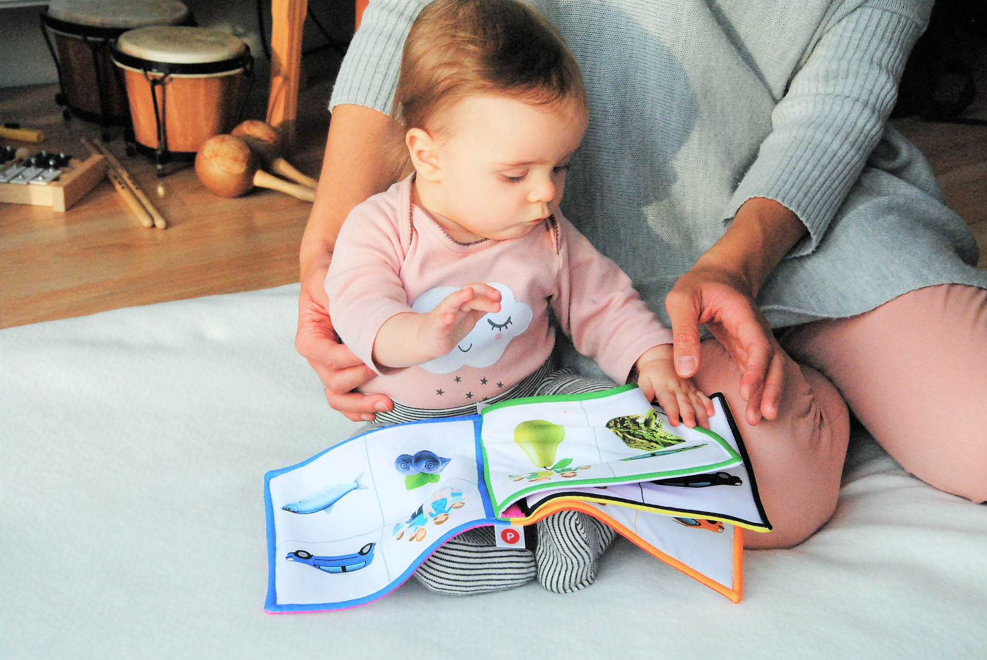 Baby With Soft Book Showing Items By Color